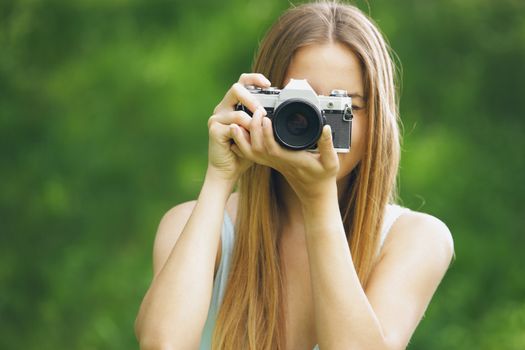 Young woman taking a picture with an old camera