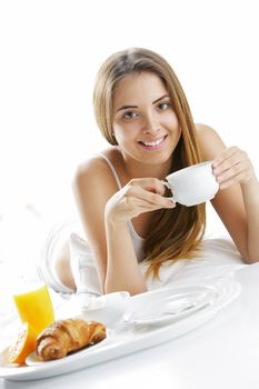 Young beautiful woman having breakfast in bed.