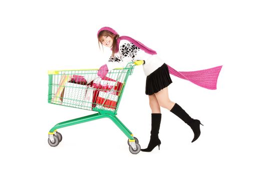 happy teenage girl with shopping cart over white