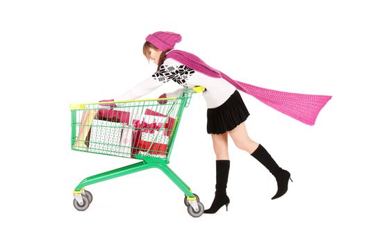 happy teenage girl with shopping cart over white