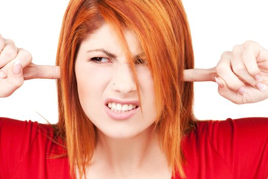 picture of unhappy redhead woman with fingers in ears