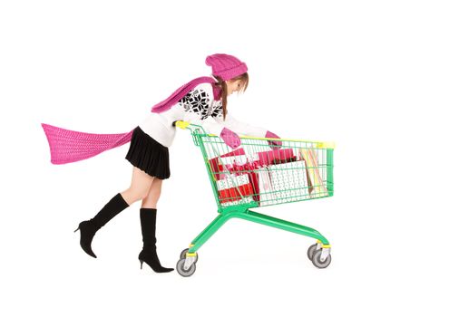 happy teenage girl with shopping cart over white