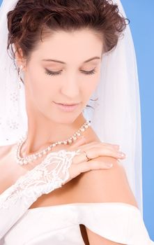 happy bride with her wedding ring over blue