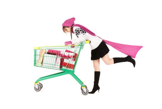 happy teenage girl with shopping cart over white