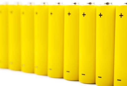 A row of yellow batteries isolated over white background