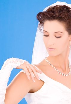 happy bride with her wedding ring over blue