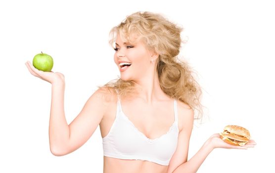 young beautiful woman choosing between burger and apple