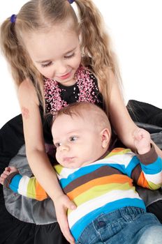 Shot of newborn baby with sister lying on white background