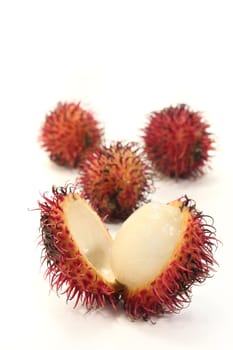 four rambutan fruits on a white background