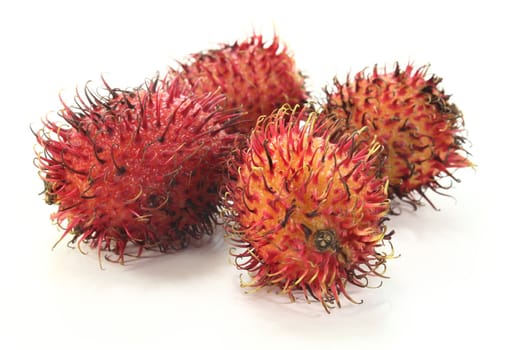 four rambutan fruits on a white background