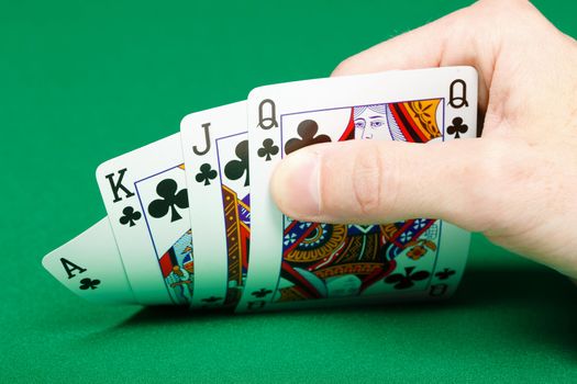 man's hand with four cards on green gaming table