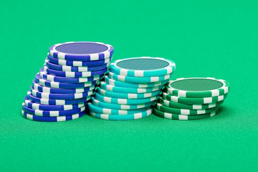 pile of playing chips on the green table