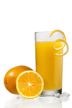 glass of orange juice with orange peeling beside oranges on a white background