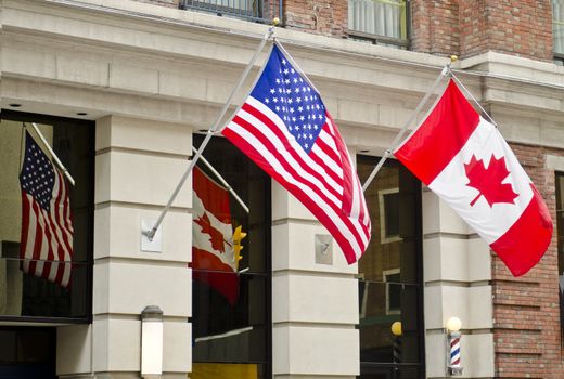 The Canadian and United States of America flags are waving proudly side by side in Ottawa, Canada.