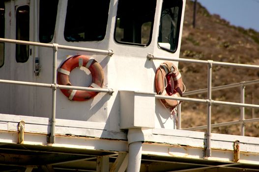 Two red and white lifesavers on deck of large boat