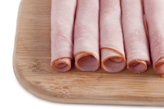 up close ham rolls in a wooden board on white background