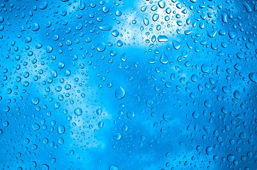 background image of rain drops on glass with a bright blue cooling color behind