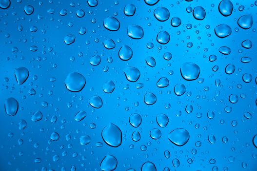 background image of rain drops on glass with a bright blue cooling color behind
