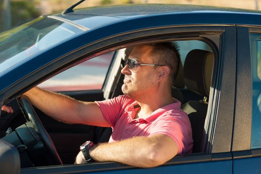 Latin guy trying to be as cool as possible behind the wheel