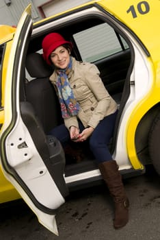 Beautiful woman exits a yellow taxi