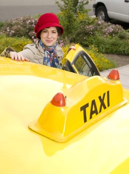 Beautiful woman enters a yellow taxi