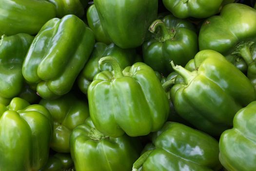 Green Bell Peppers at the farmers market with sharp focus on center vegetable