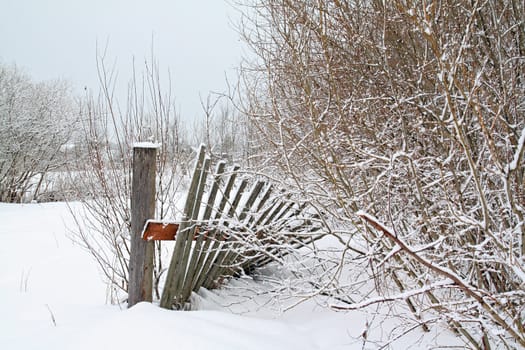 old wooden fence amongst white snow