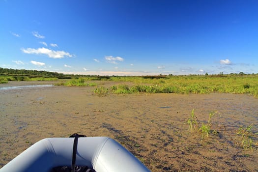 rubber boat on green marsh