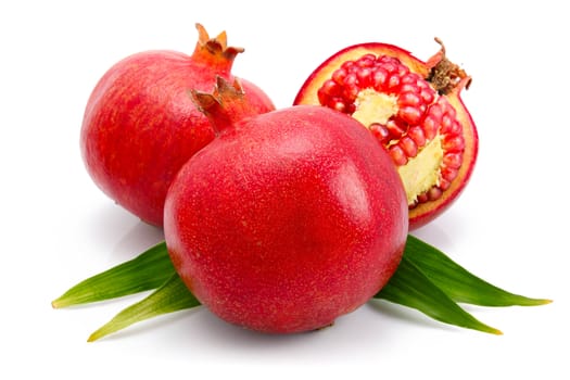 pomegranate fruits with green leaf and cuts isolated on white background 