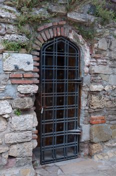 Ancient door grill in the old brick wall.