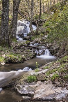 Cascades on a mountain river with a silky effect on the water that conveys a sense of relaxation.