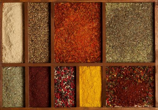 Spicy Spices in Wooden Box as Background close up