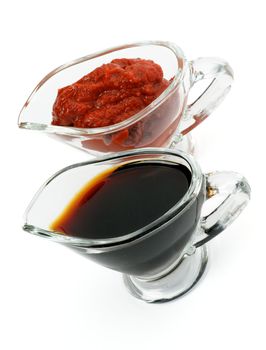 Arrangement of Soy Sauce and Ketchup in Glass Gravy Boat isolated on white background