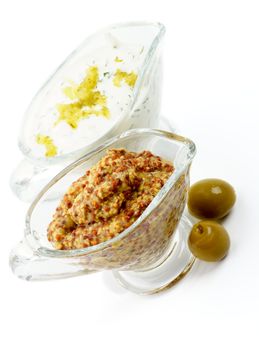 Whole Grain Mustard and Tartar with Olives in Glass Gravy Boat isolated on white background