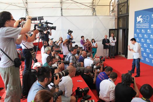 Wang Bing poses for photographers at 69th Venice Film Festival