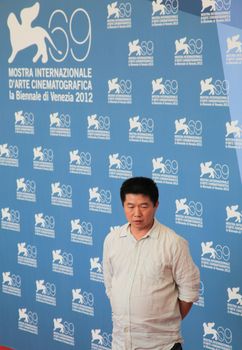 Wang Bing poses for photographers at 69th Venice Film Festival