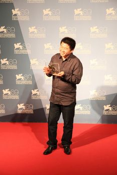 Wang Bing poses for photographers at Venice Film Festival