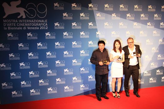 Wang Bing, Yoo Min-young and Frederic Fonteyne pose for photographers at Venice Film Festival