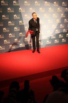 Olivier Assayas poses for photographers at Venice Film Festival