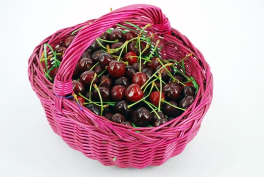 Basket with cherries isolated on white