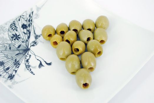 Green fresh olives on dish