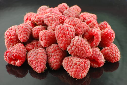 Fresh raspberry on black dish