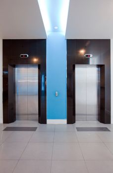 Front view of a modern elevator with closed doors in lobby