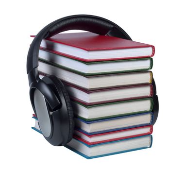 Headphones worn on a stack of books with color covers isolated on white background.