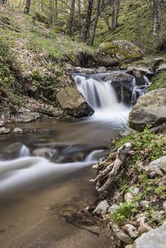 Cascades on a mountain river with a silky effect on the water that conveys a sense of relaxation.