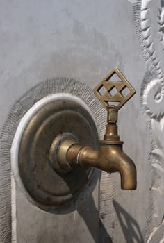 Tap water in the stone wall on the street.