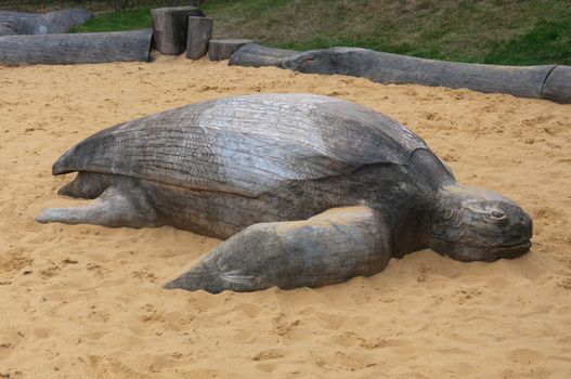 Large wooden sea turtle in the children's sandbox.