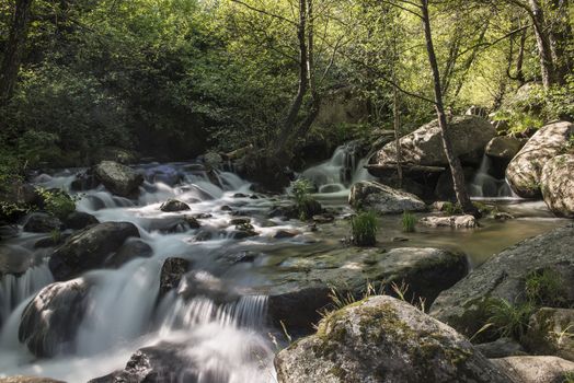 Cascades on a mountain river with a silky effect on the water that conveys a sense of relaxation.