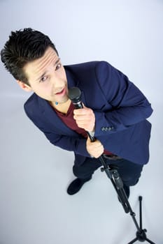 Singer with microphone standing and looking into camera