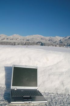 Laptop in a snowy winter landscape scene